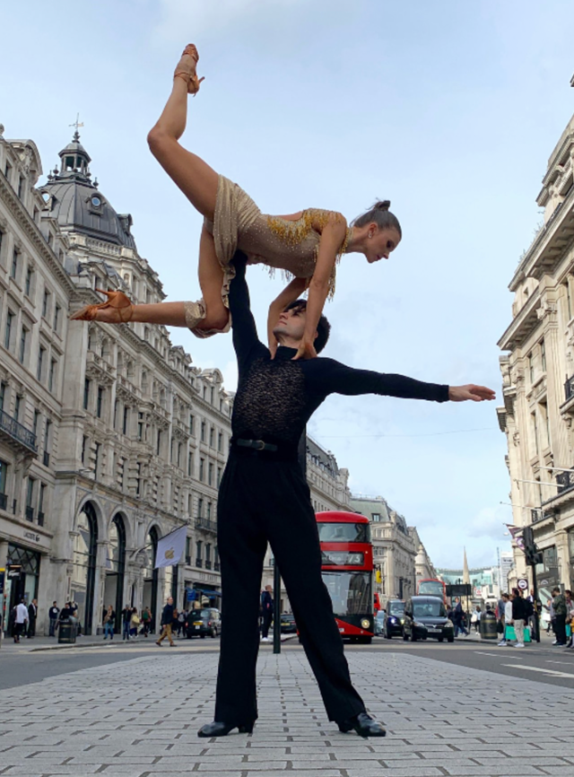 Two dancers, leader lifts follower.