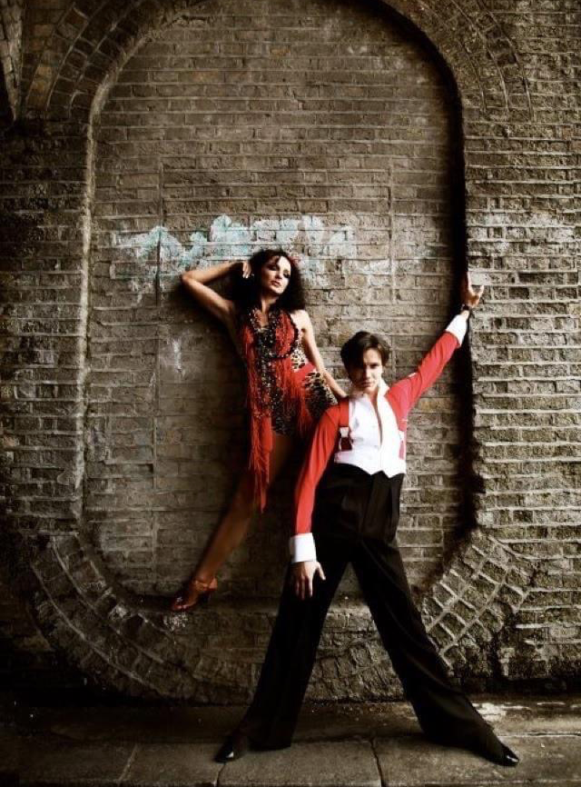 Photoshoot with two dancers wearing ballroom infront of a brick wall.