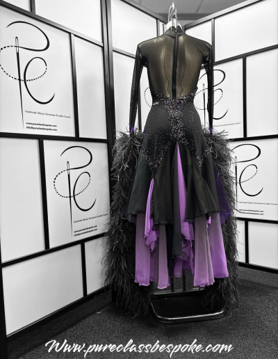 Back of a black and purple feathered couture gown.