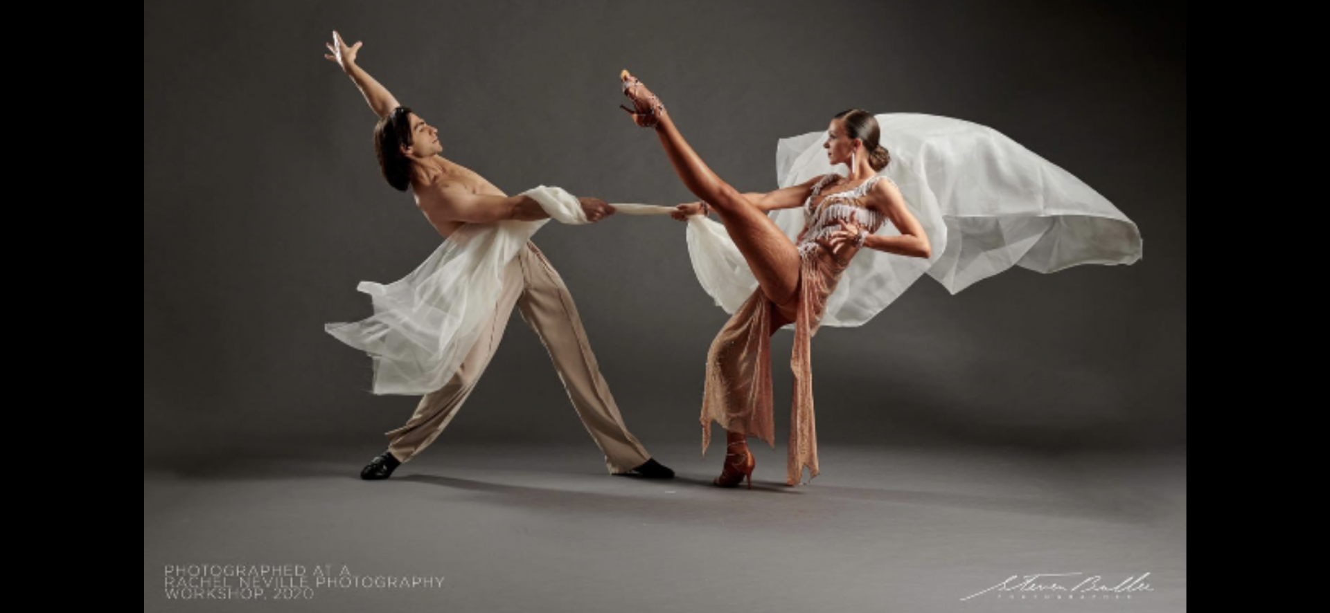 Two dancers, man and lady in an elaborate dance wearing Pure Class Bespoke attire.